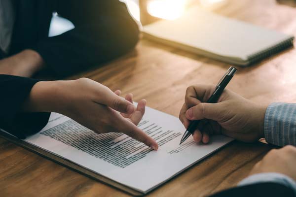 Client signing legal documents with an attorney